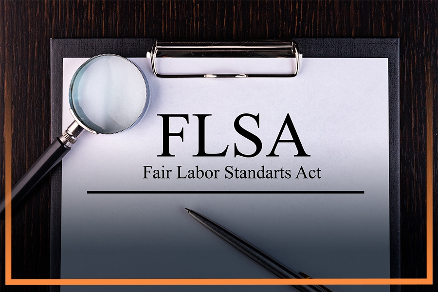 Fair Labor Standards Act on a wooden clipboard with a magnify glass and pen in Atlanta